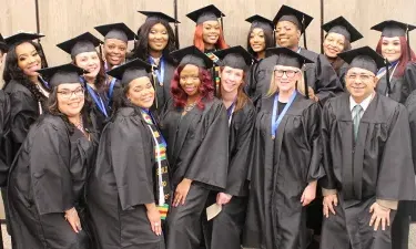 Group of Herzing University graduates smiling after graduation ceremony